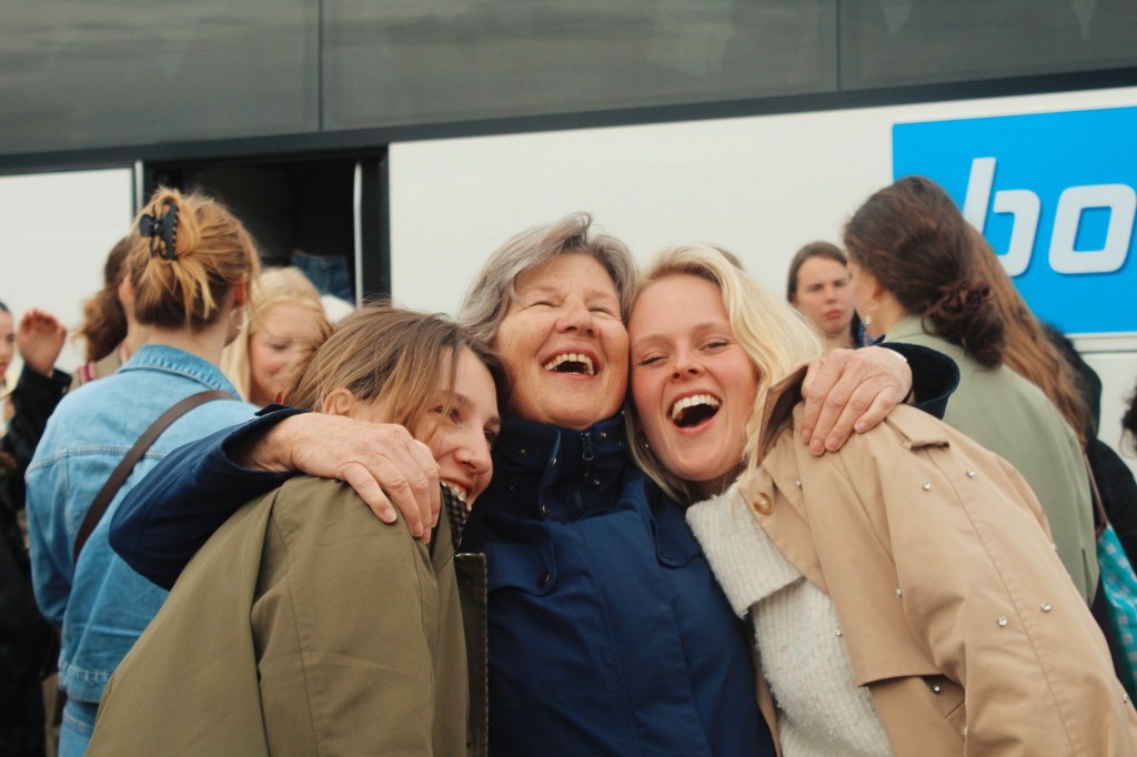 Jongeren en een senior knuffelen bij de bus tijdens een Careibu-citytrip